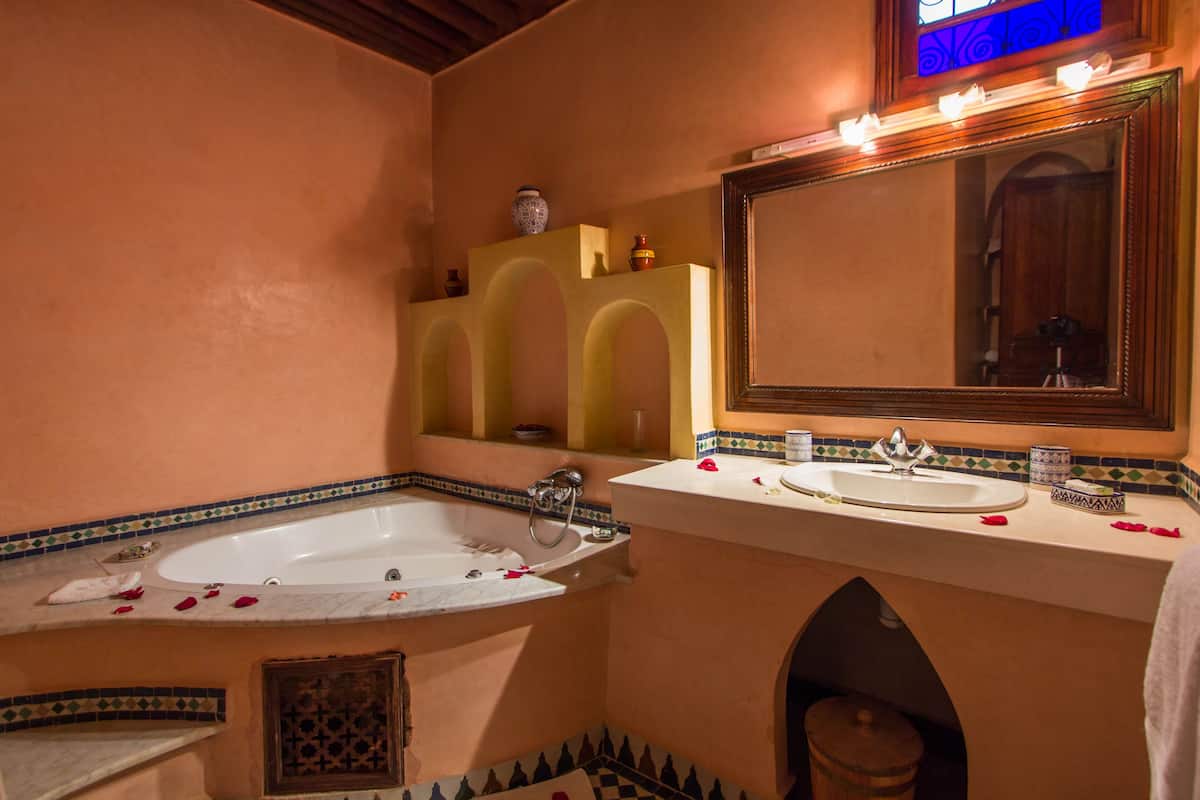 deluxe suite, jetted tub | bathroom | deep-soaking bathtub, free toiletries, hair dryer, bathrobes