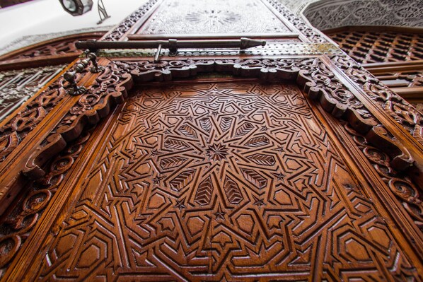A detailed wooden door with intricate geometric patterns and a central star design.