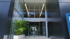 La entrada del Hotel Hiroshima, con fachada de vidrio y un letrero sobre las puertas.