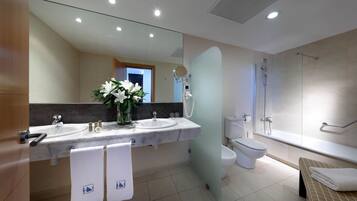Un baño moderno con dos lavamanos, un inodoro, una ducha y un banco.