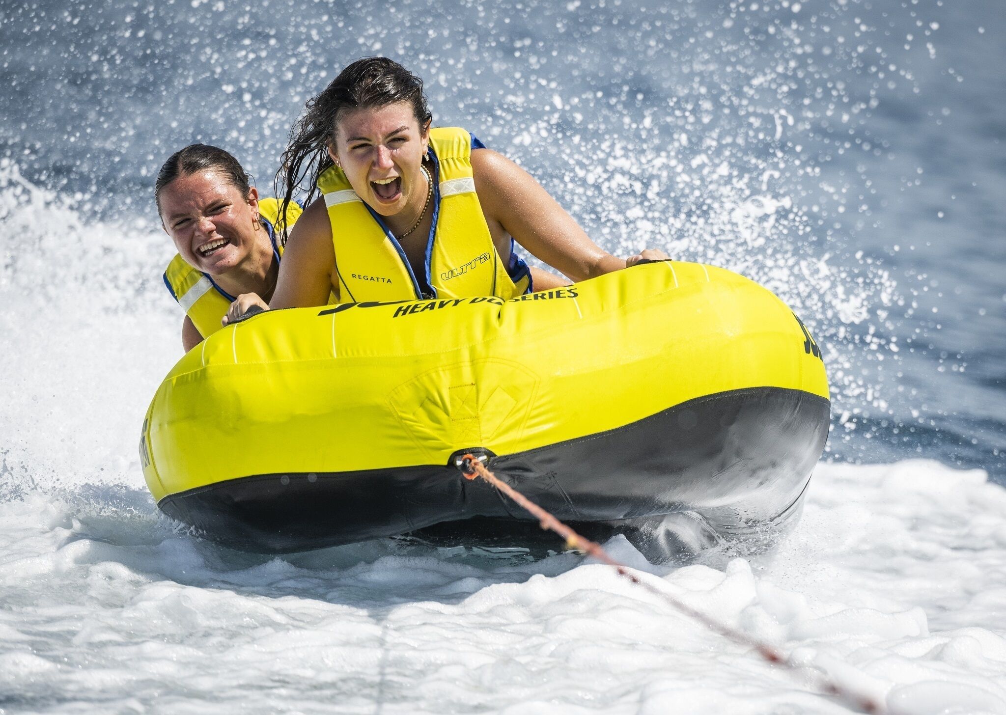 Dos personas en una balsa inflable amarilla sobre una superficie nevada.