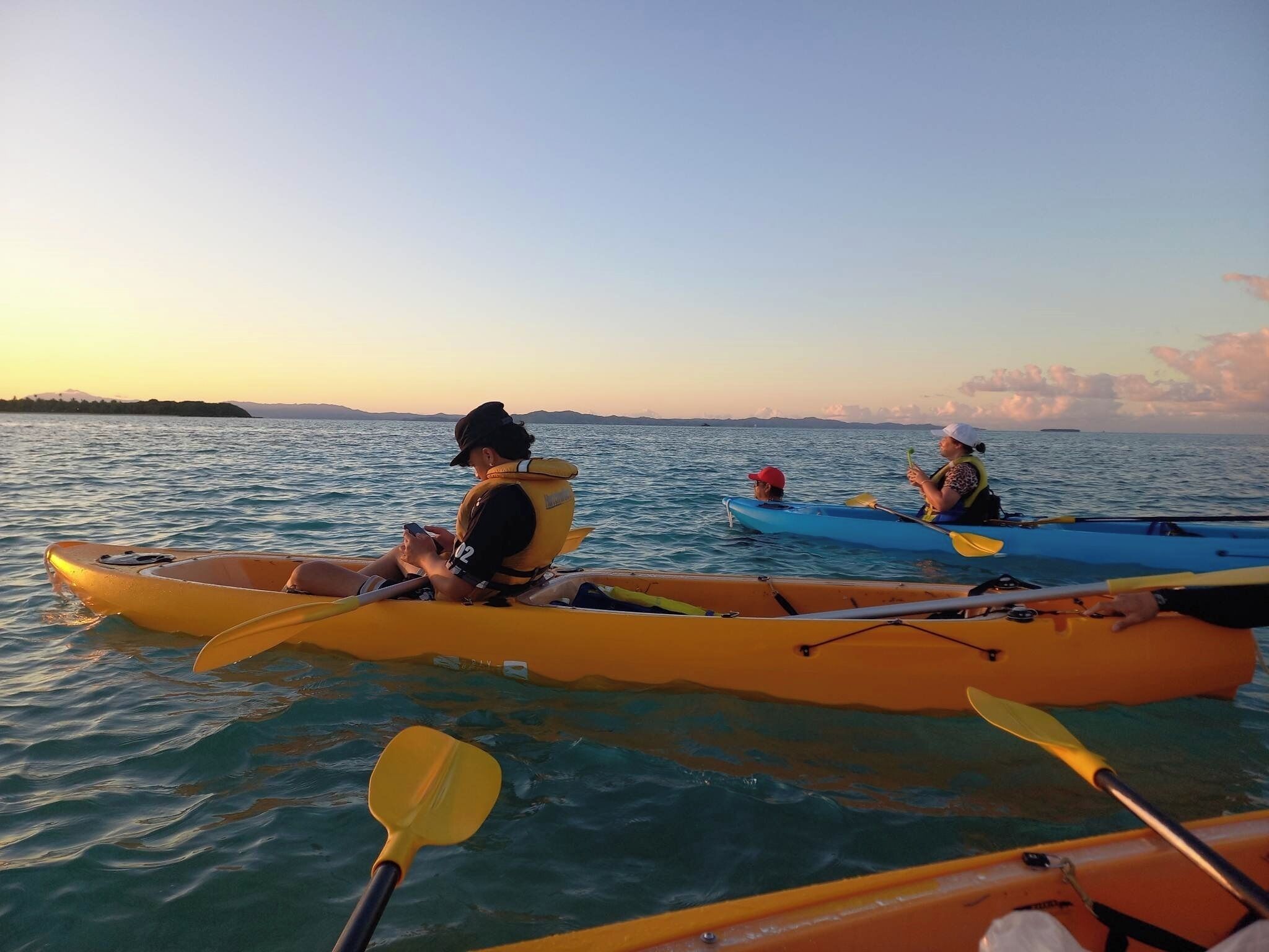 Deux kayaks sur une eau calme, sous un ciel dégagé.