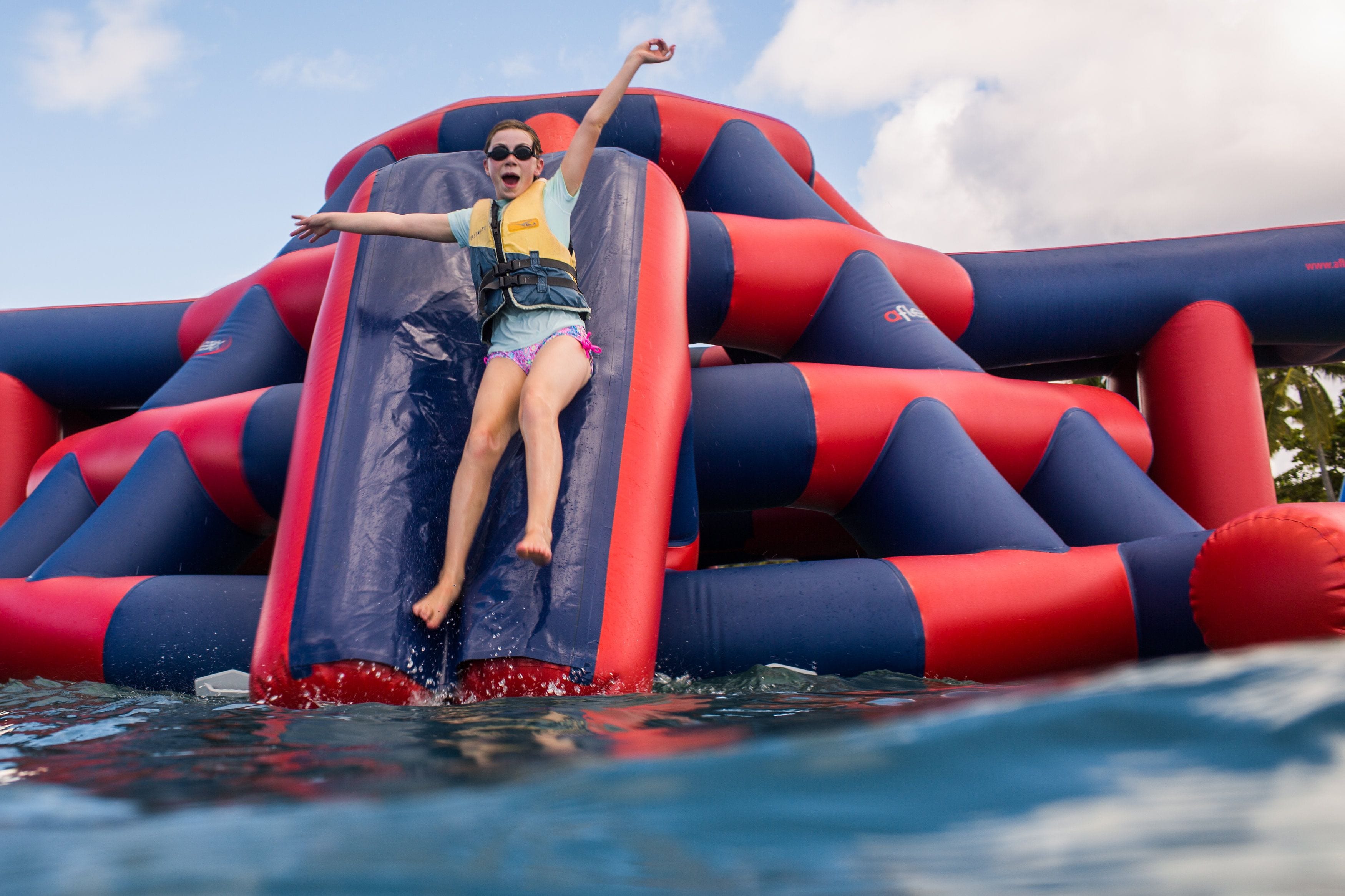 Une personne dévale un grand toboggan aquatique gonflable.