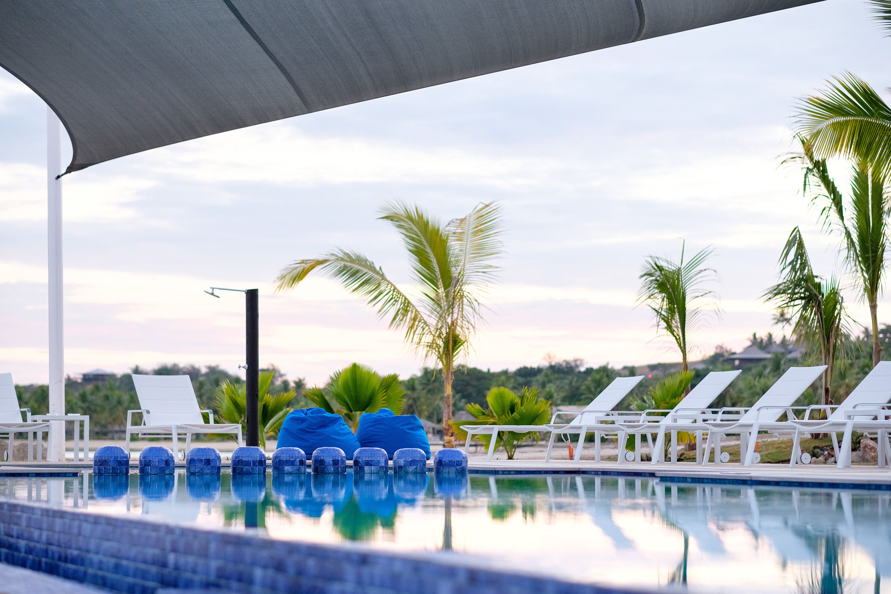 Un área de piscina con sillones de descanso y una pérgola.
