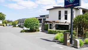 A modern motel with a sign indicating vacancy. - Alpine Lake Motor Lodge (Taupo)