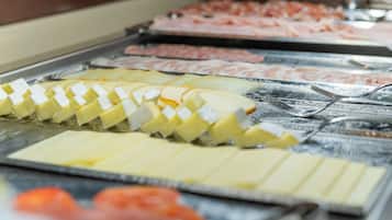 A buffet with various food items including cheese, ham, and other meats.