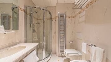 A modern bathroom with a glass-enclosed shower, a built-in toilet, and a sink.