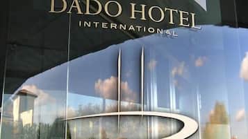 Reta del Dado Hotel International amb una façana de vidre que reflecteix el cel i una estructura d'edifici moderna.
