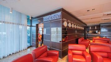 Ein Restaurant mit modernem Interieur, roten Ledersitzen und einem Schild mit dem Namen und dem Ort.