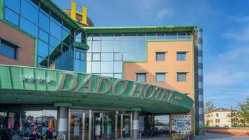A hotel with a green marquee and a large H on the building.