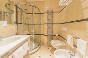 Un baño moderno con ducha envuelta en vidrio, un lavabo, un inodoro y una bañera.