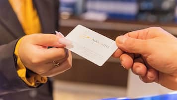 Eine Person hält eine Visitenkarte vom Dado Hotel.