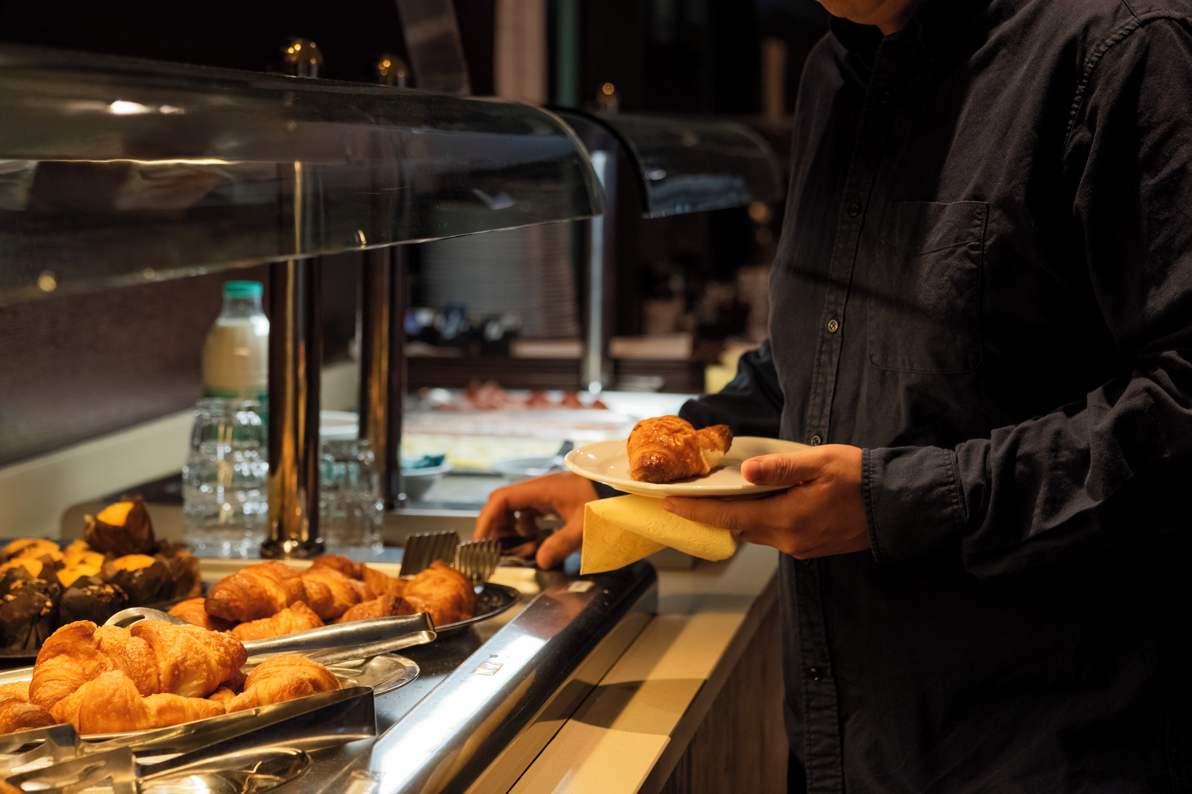 A buffet with various pastries and a bottle of juice.