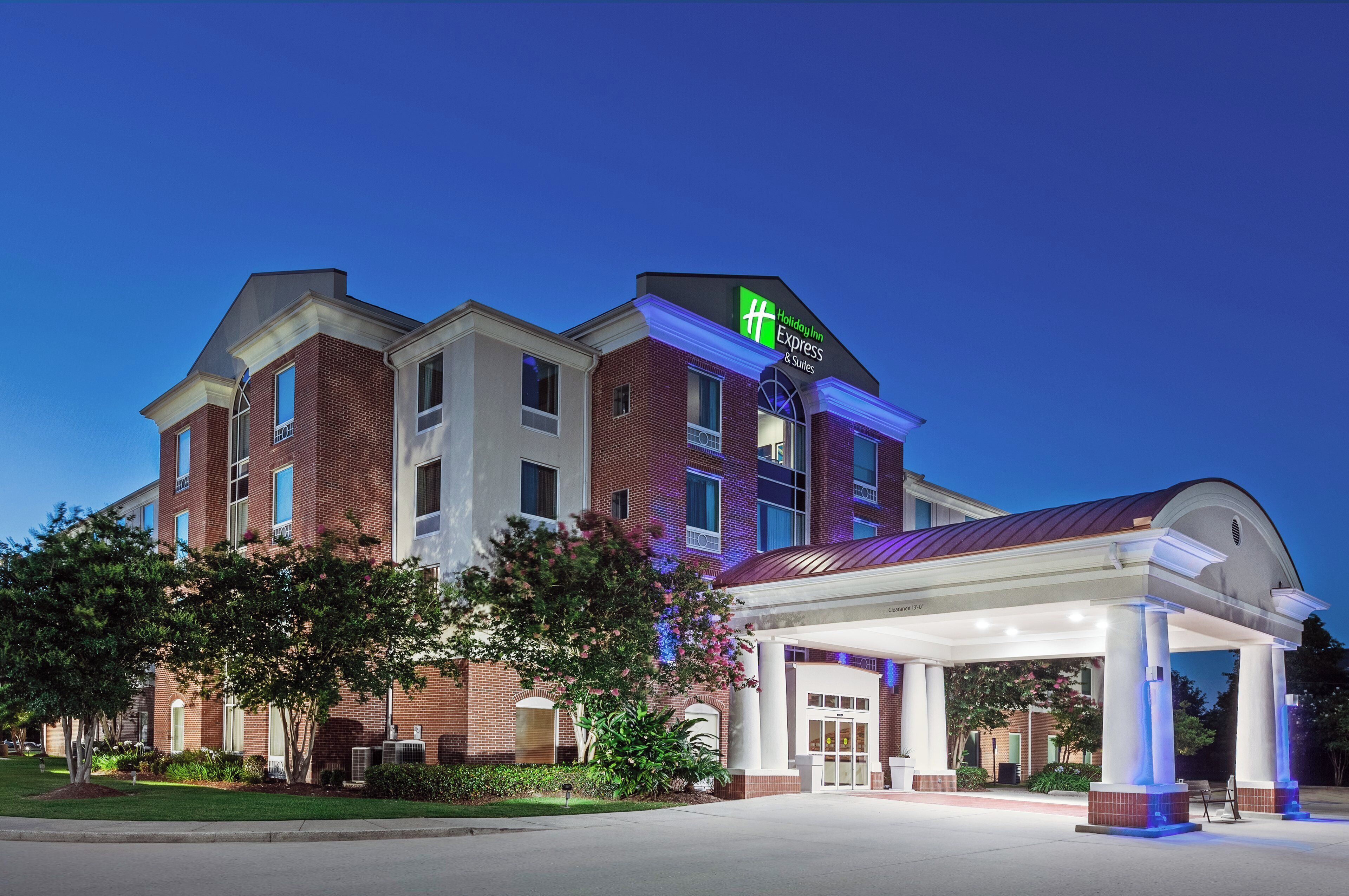 A Holiday Inn Express & Suites hotel with a covered entrance and a brick facade.