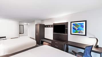 A hotel room with a bed, a desk with a chair, a TV, and a cabinet.