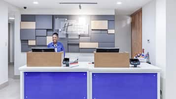 Una reception dal design moderno, una segnaletica con la scritta 'Holiday Inn Express & Suites' e una telecamera di sicurezza sopra.