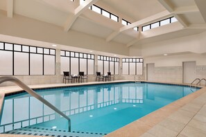 An indoor swimming pool with clear blue water, tiled walls, and a high ceiling with skylights. - Holiday Inn Express Hotel & Suites Atlanta-Cumming by IHG (Cumming)