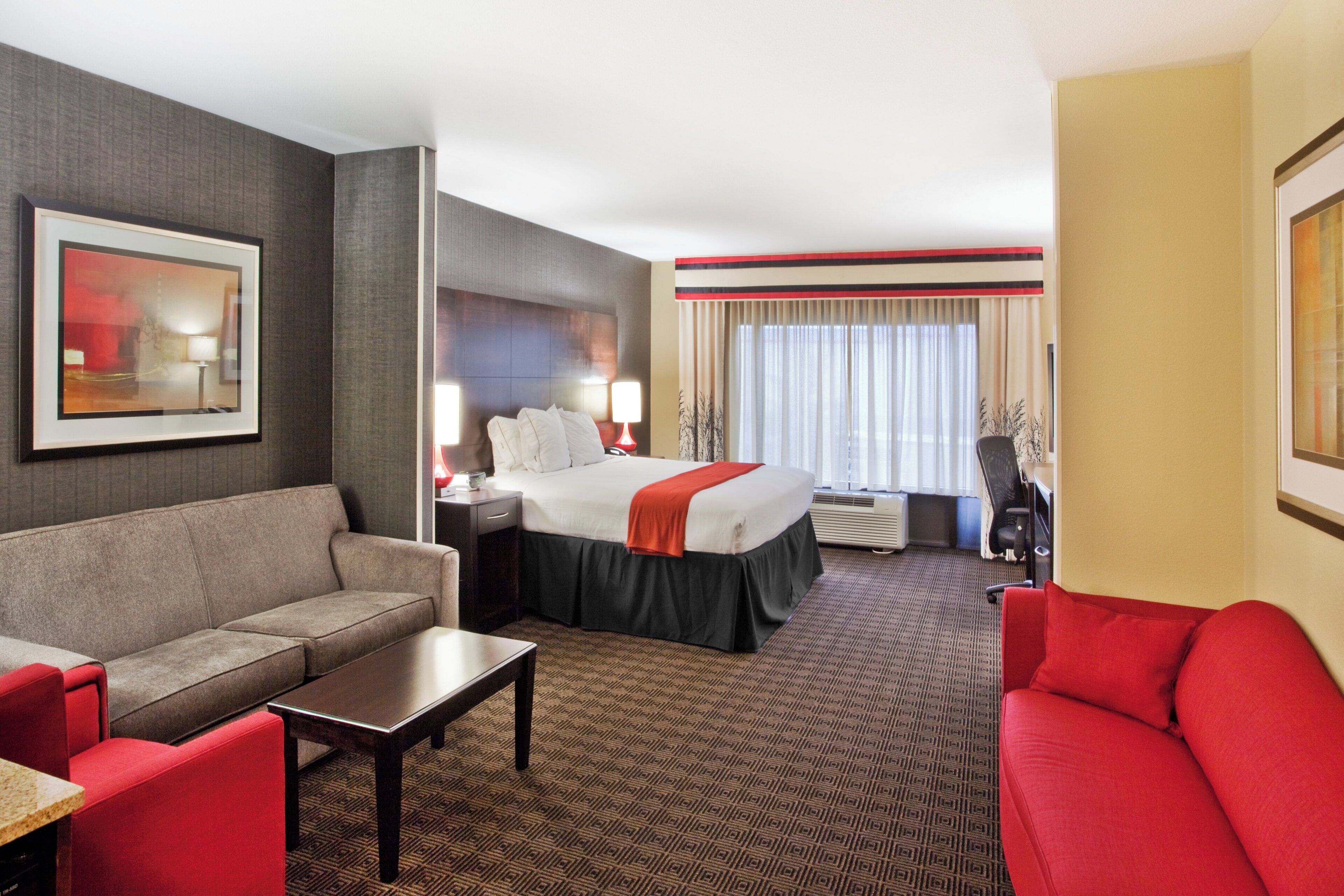 Ein Hotelzimmer mit einem Bett, einem Sofa, einem Schreibtisch und einem Sessel.