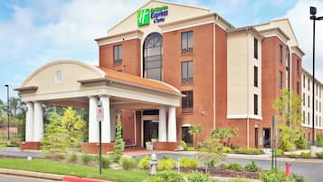 Ett Holiday Inn Express & Suites-hotell med en fasad av tegel, en överbyggd entré och en skylt som visar var utryckningsfordon får köra.