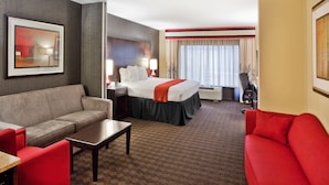 Una habitación de hotel con una cama, un sofá, una mesa de centro y un escritorio.