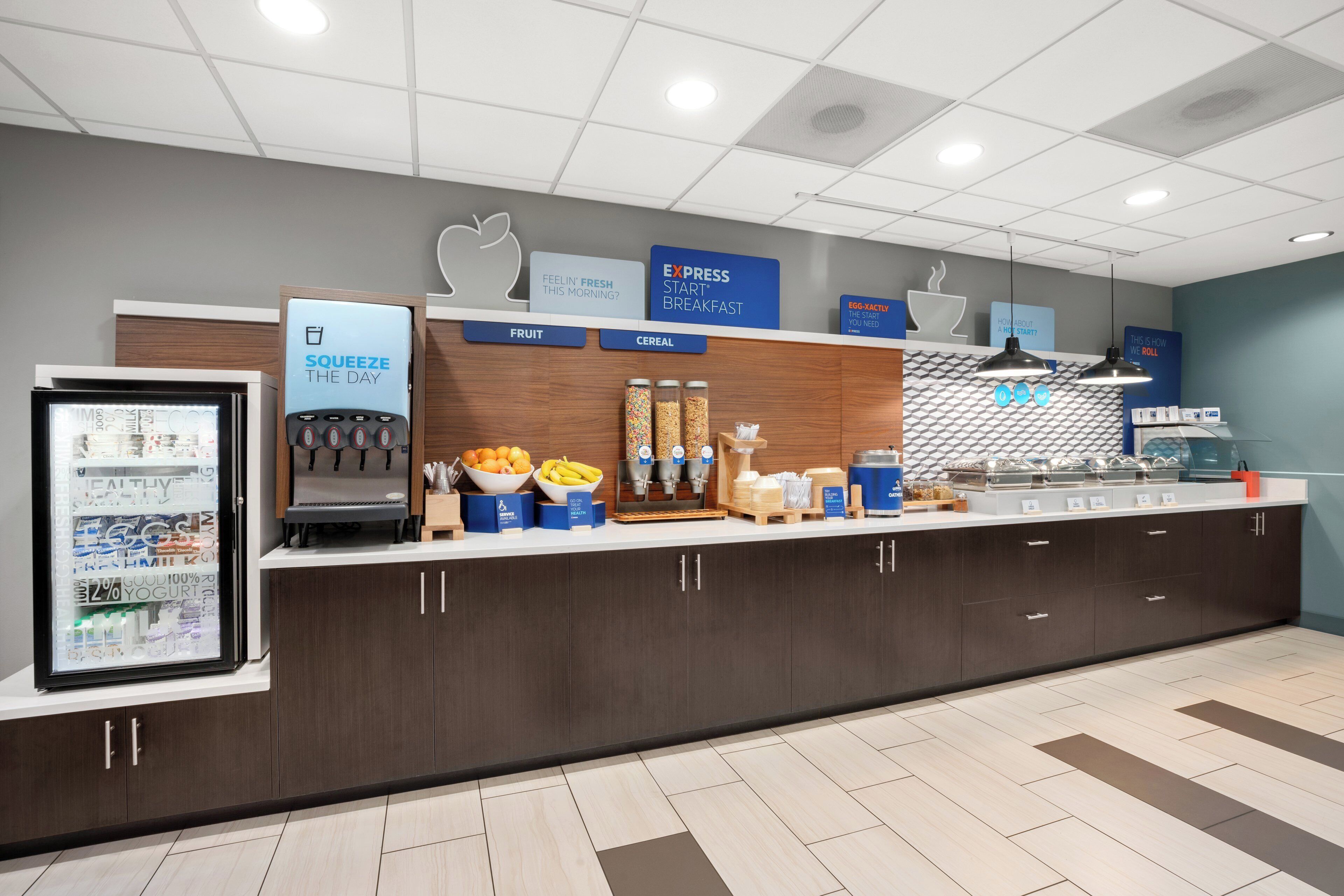 A breakfast area with a refrigerator, coffee machine, and various food containers.