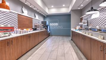 A modern kitchen with wooden cabinets, a breakfast bar, and a "GOOD MORNING" sign.