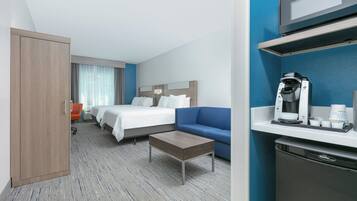 Ein Hotelzimmer mit einem Bett, einer Couch, einer Kaffeemaschine und einer Mikrowelle.