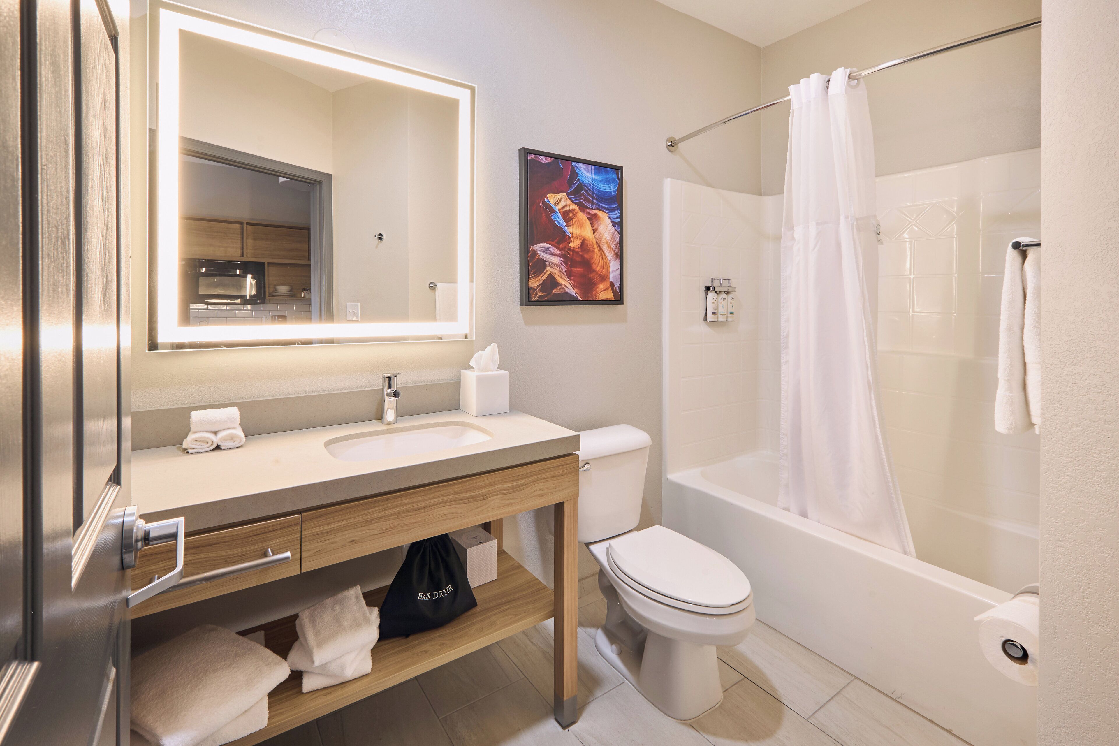 A modern bathroom with a sink, toilet, and shower.