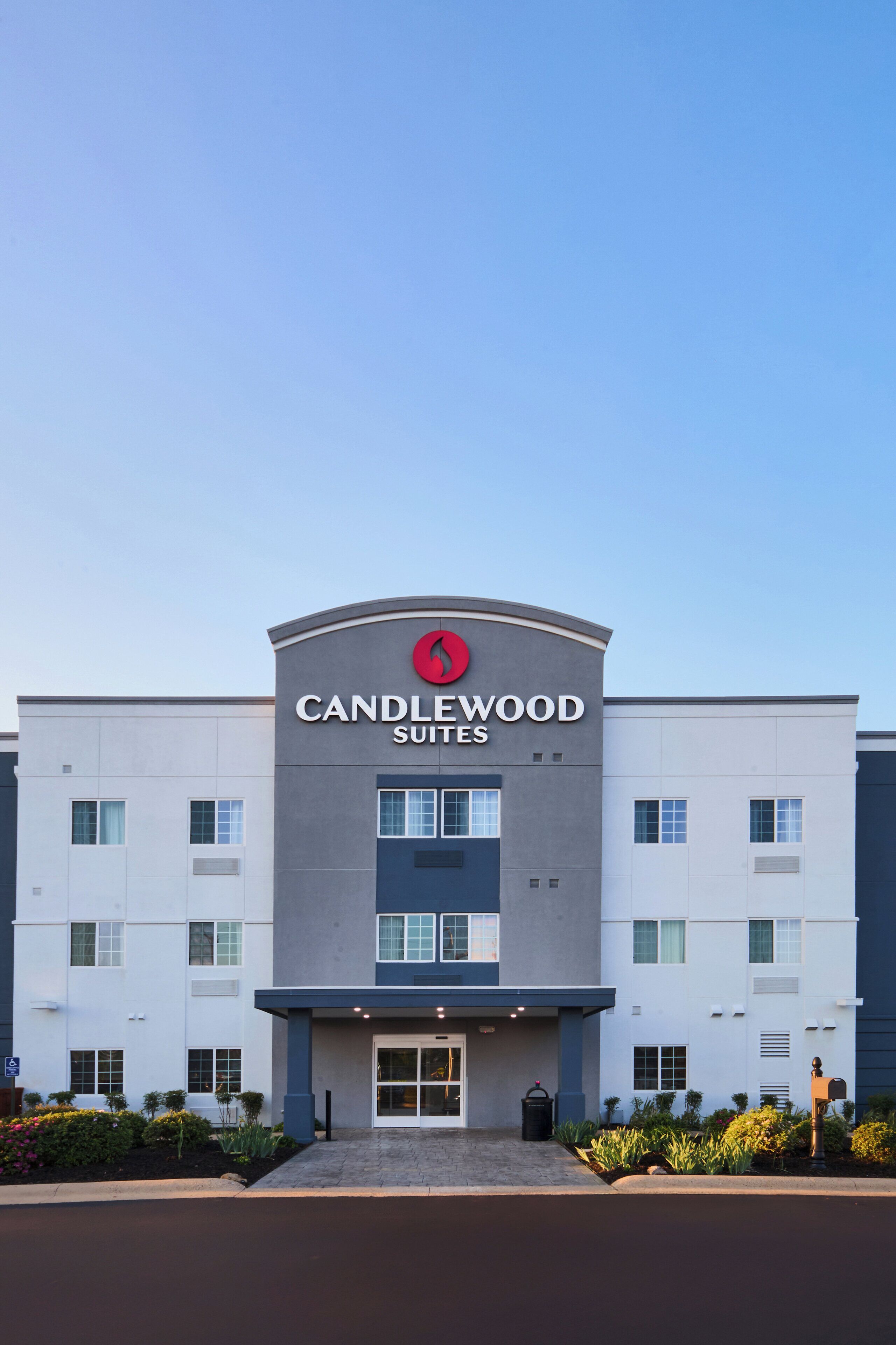 En modern hotellbyggnad med en framträdande skylt som visar texten ”CANDLEWOOD SUITES”.