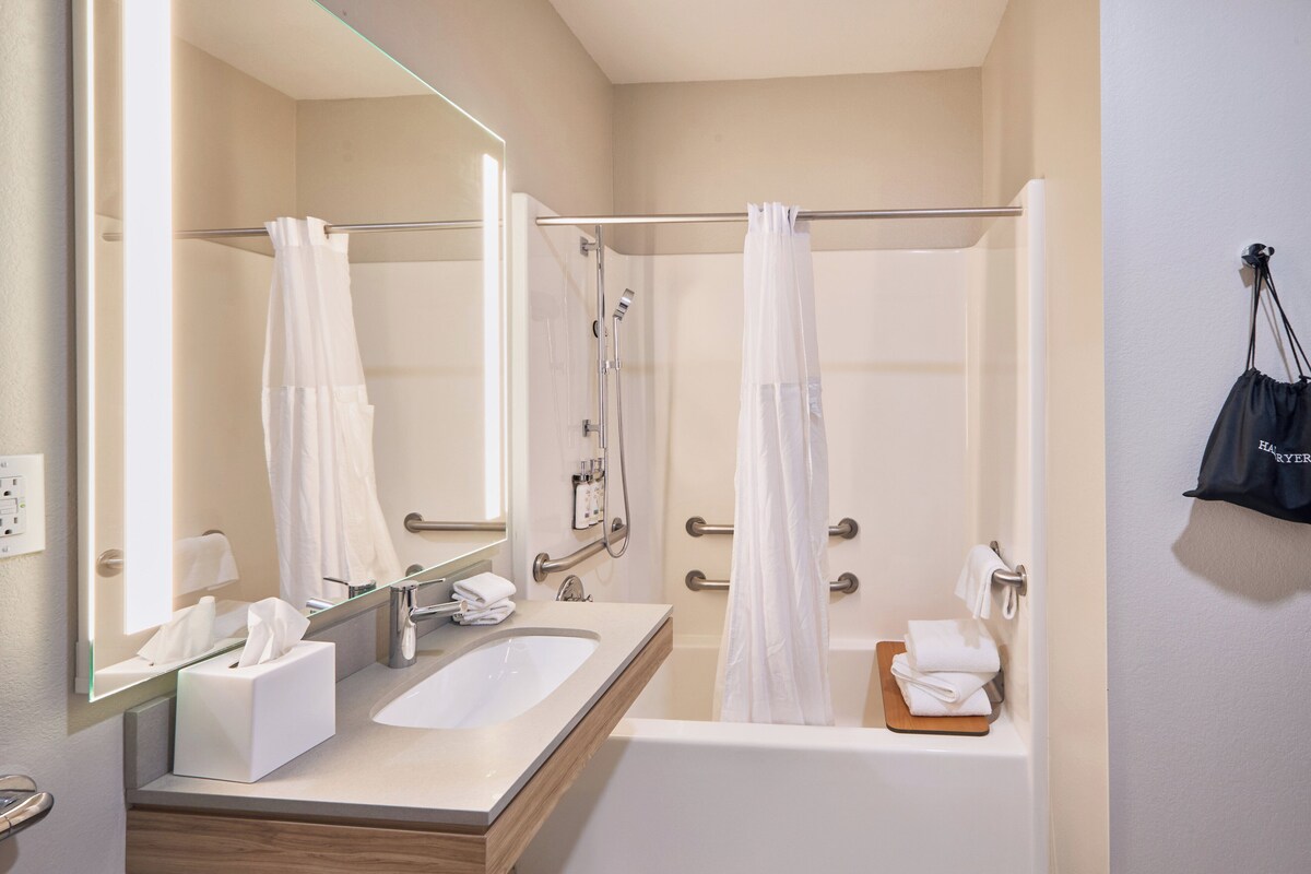 Une salle de bain moderne équipée d’une baignoire, d’une douche et d’un lavabo.