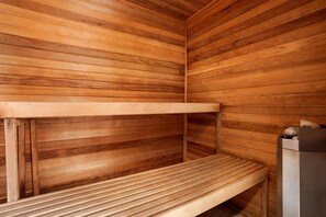 A sauna with wooden benches and a stone heater.