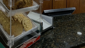 A bakery display with multiple trays of cookies.