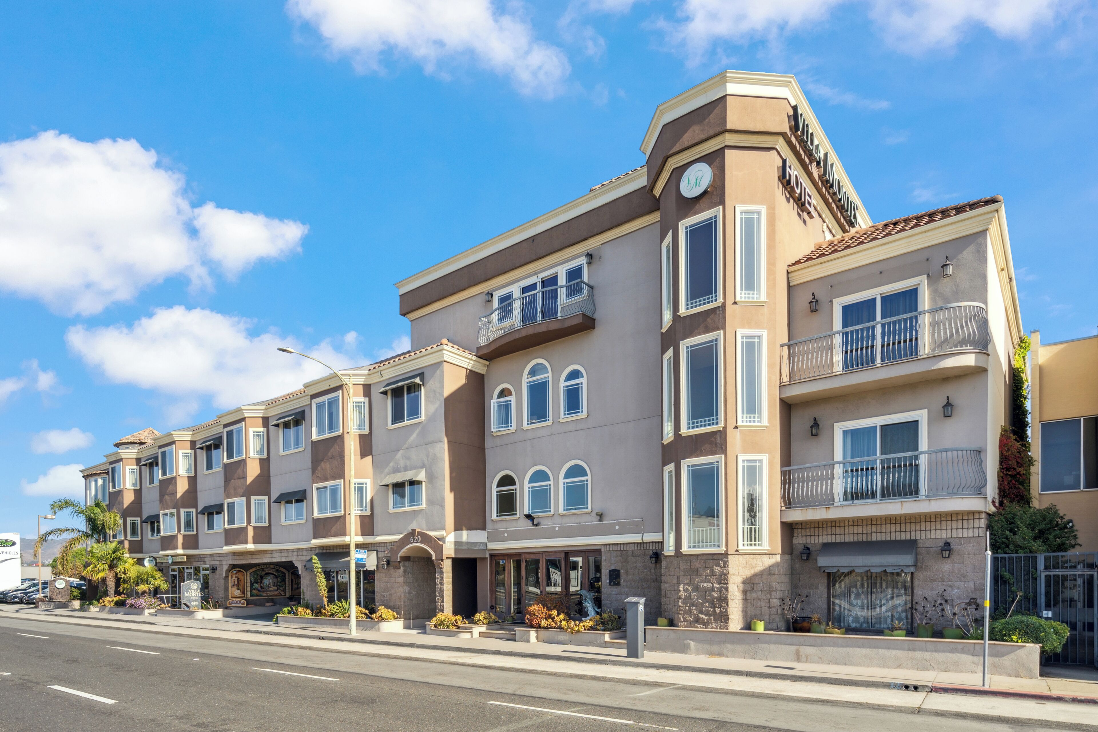 A multi-story hotel with a modern architectural design, featuring balconies and large windows.