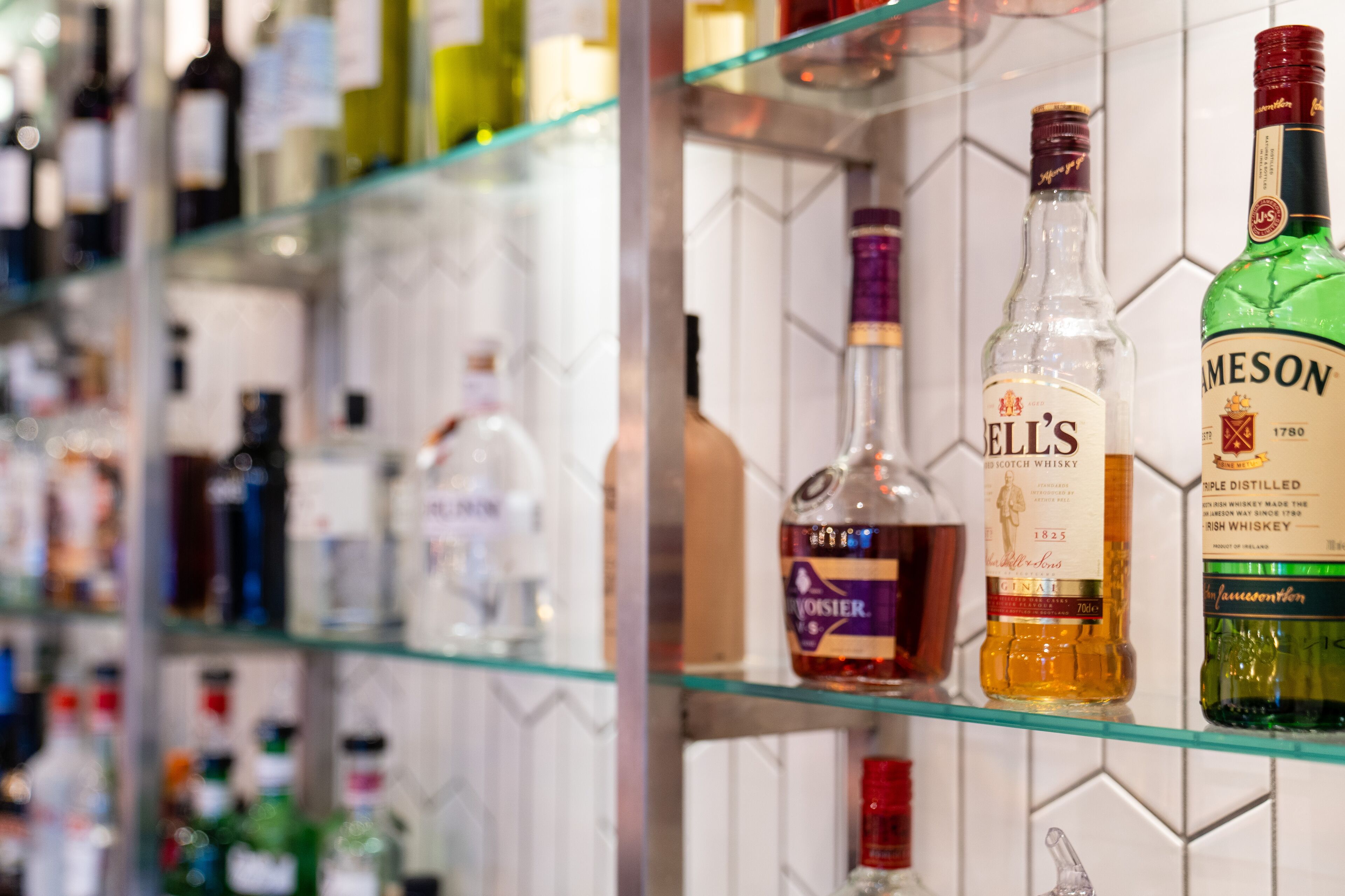 Un bar con varias botellas de alcohol en estanterías.