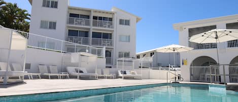 Piscine extérieure, parasols de plage, chaises longues