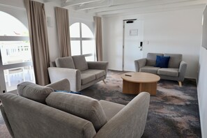 Apartamento ejecutivo, 3 habitaciones | Zona de estar | Una televisión, libros