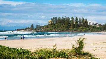 Beach nearby, white sand, beach towels, surfing
