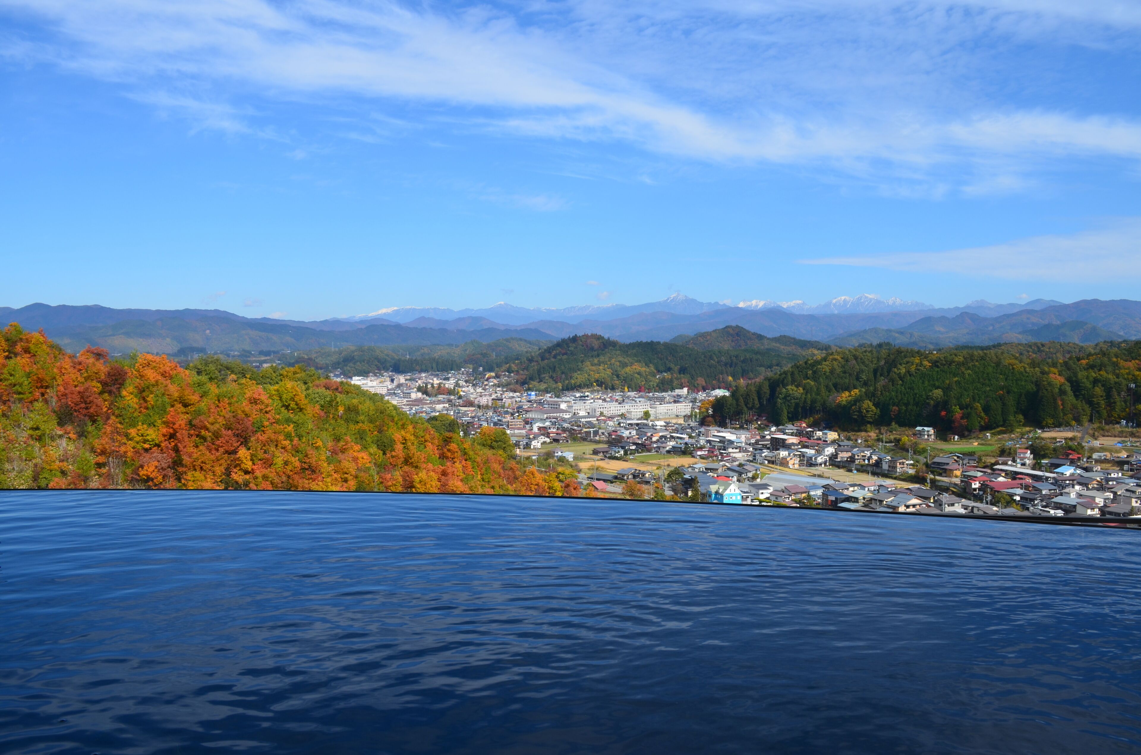 A coastal town with a view of the sea and mountains in the background.