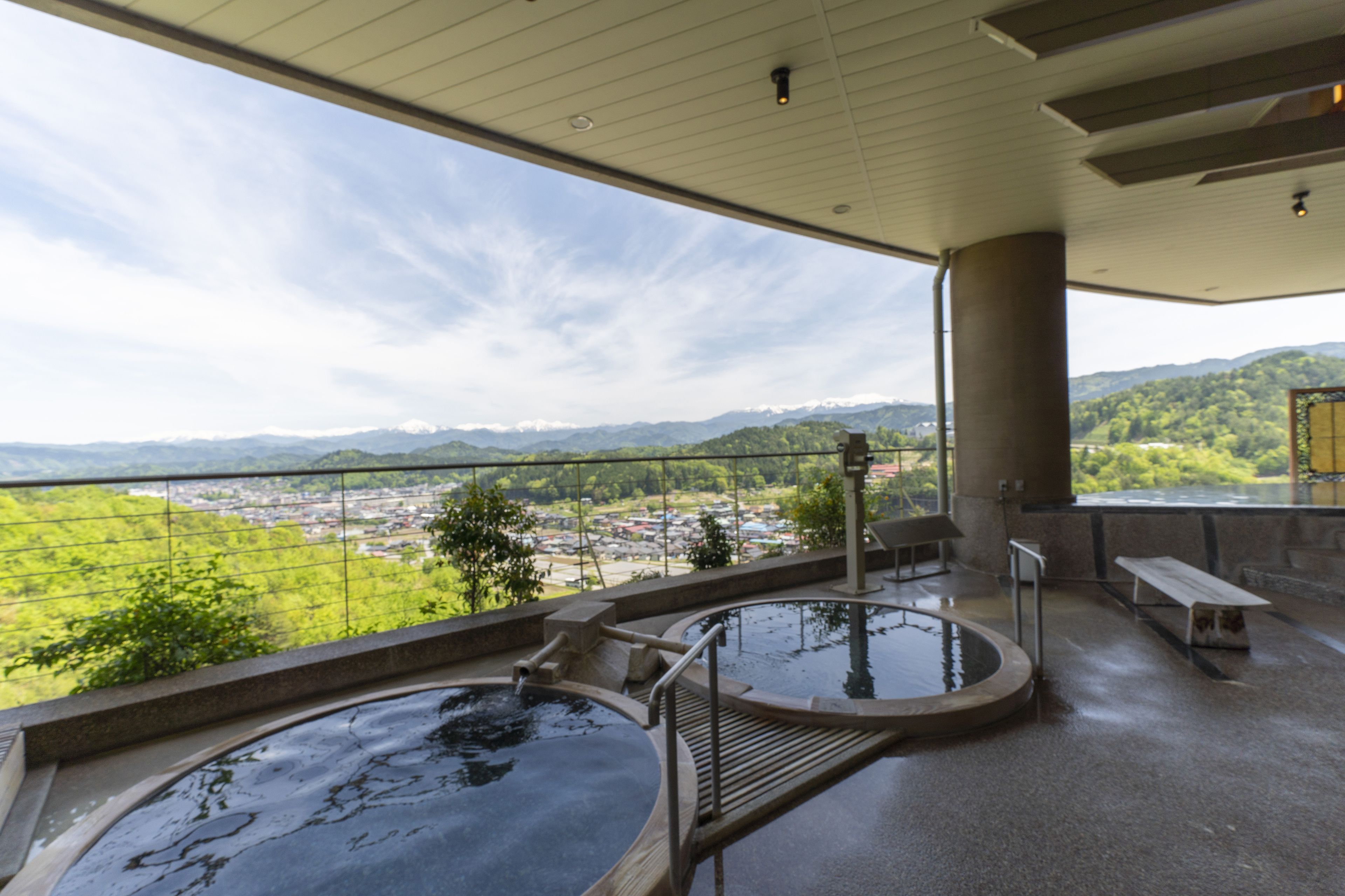 A spa area with hot tubs and a view of a town and mountains.