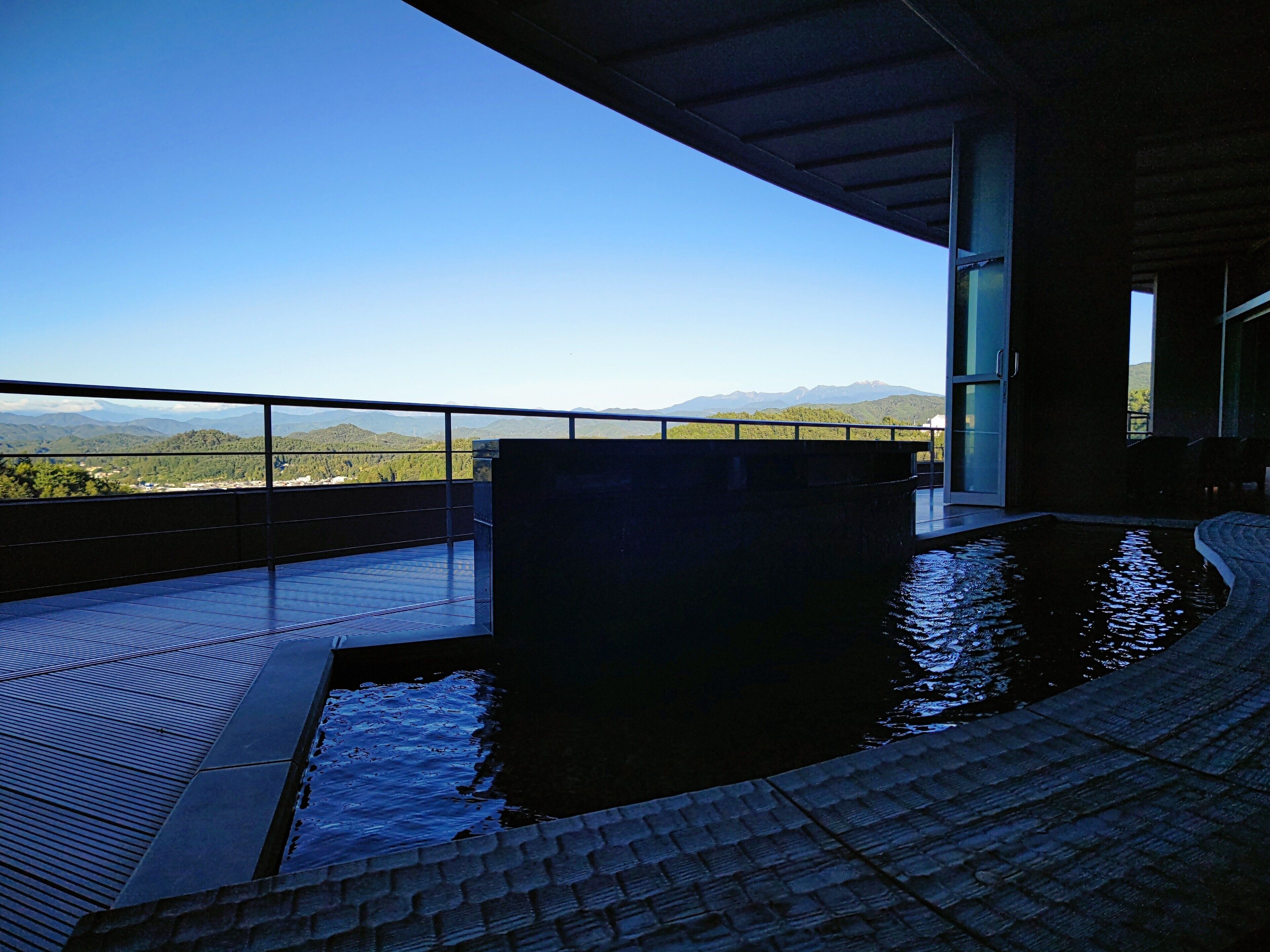 A pool area with a view of mountains and a clear sky.