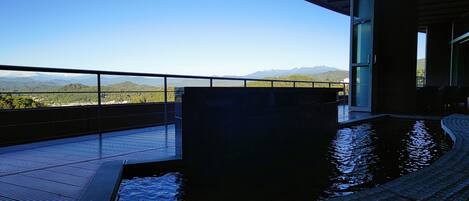 Área da piscina com vista para montanhas e céu claro.