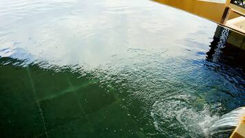 A view of a boat's deck with water splashing on the surface.