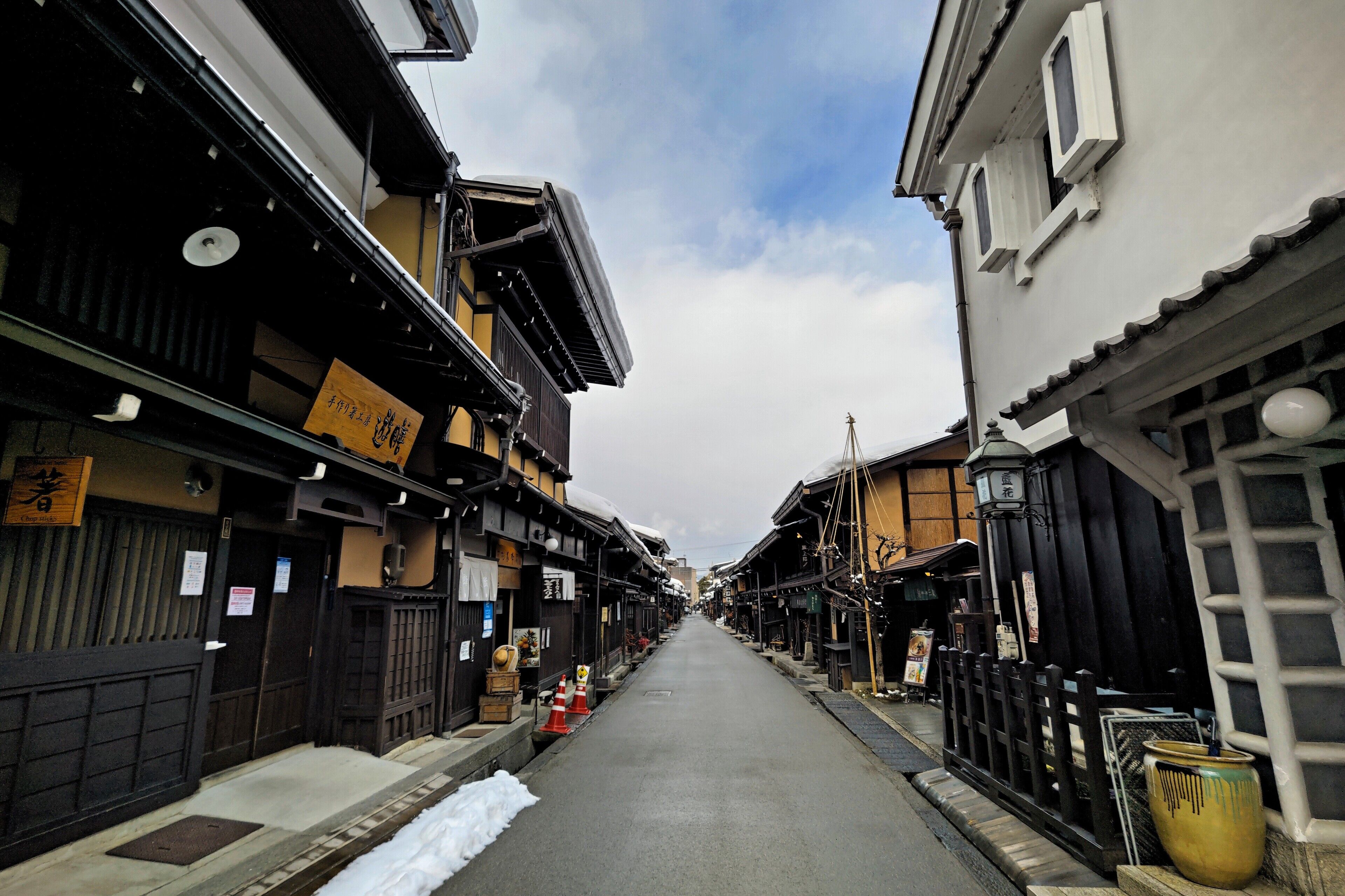 A narrow street lined with traditional buildings, some with signs indicating local businesses.