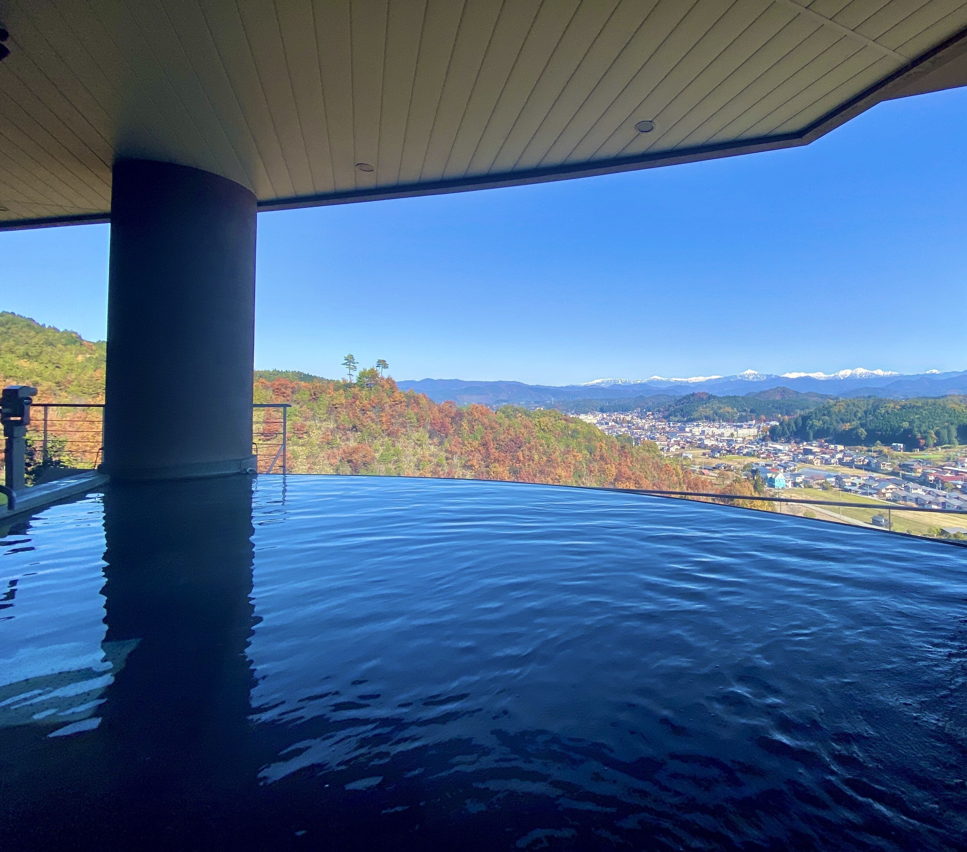 Un jacuzzi bajo techo con vistas a un pueblo y montañas.