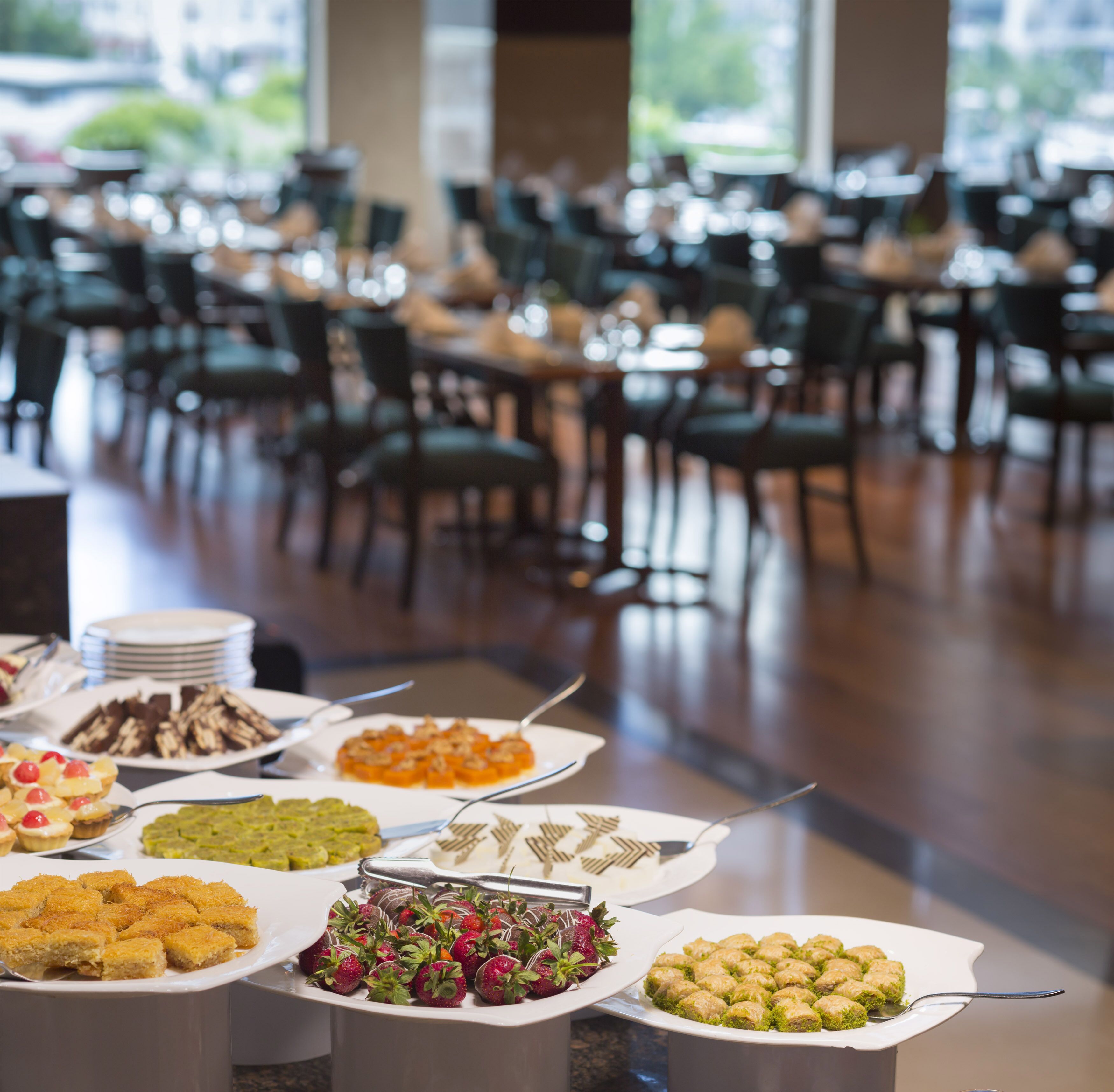 A buffet setup with various food items and a seating area in the background.