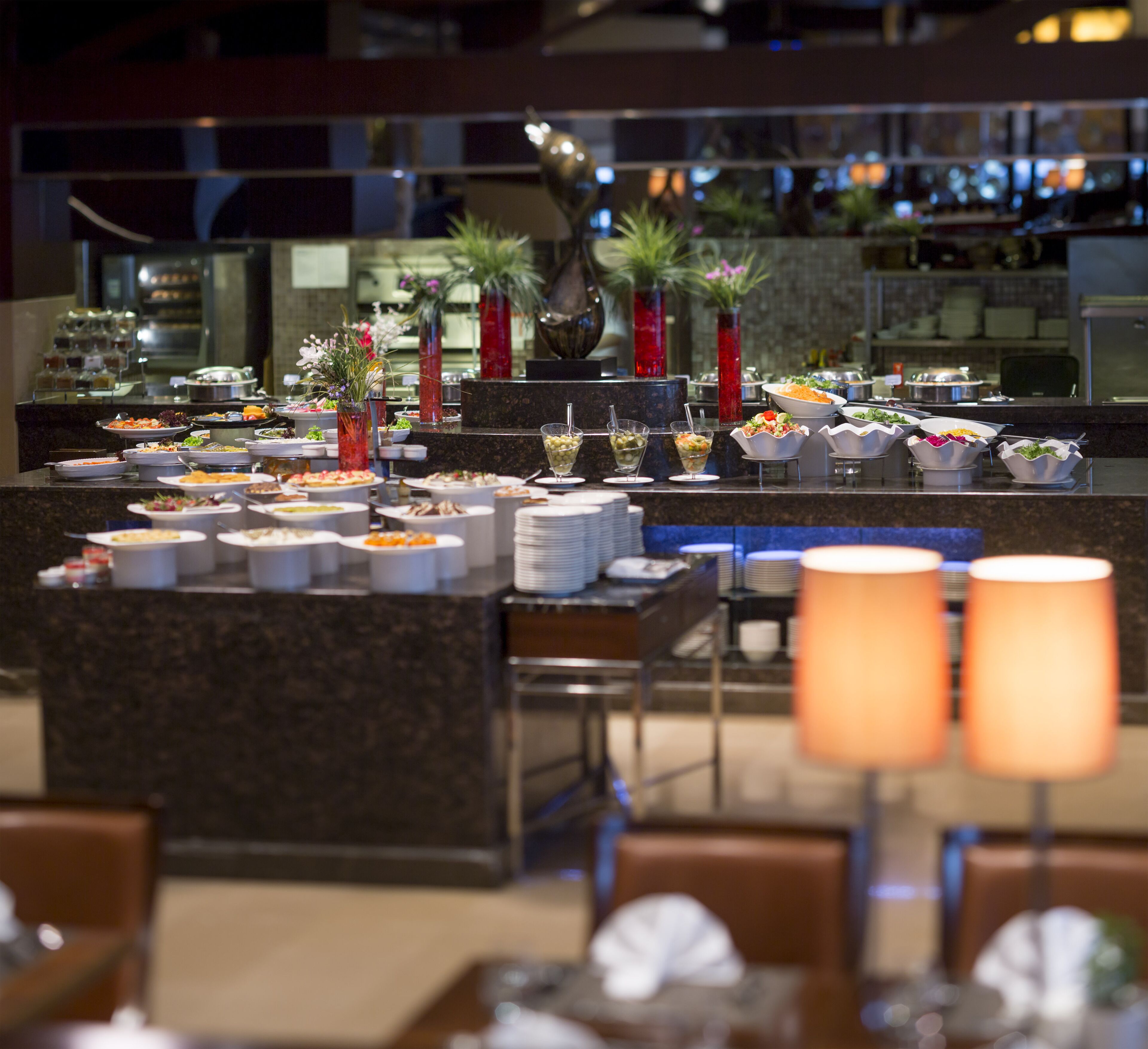 A buffet area with various food stations and decorative vases.