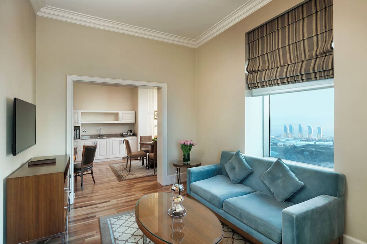 A modern living room with a blue sofa, a coffee table, and a TV on a wooden cabinet.