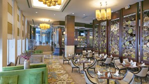 A hotel lobby with a bar, seating area, and decorative wall. - Titanic Business Kartal (Istanbul)