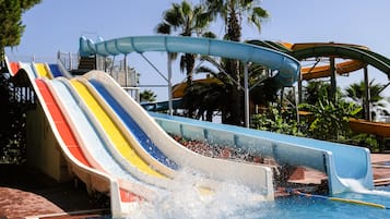 Experience the thrill of water slides surrounded by lush greenery and vibrant tropical plants.
