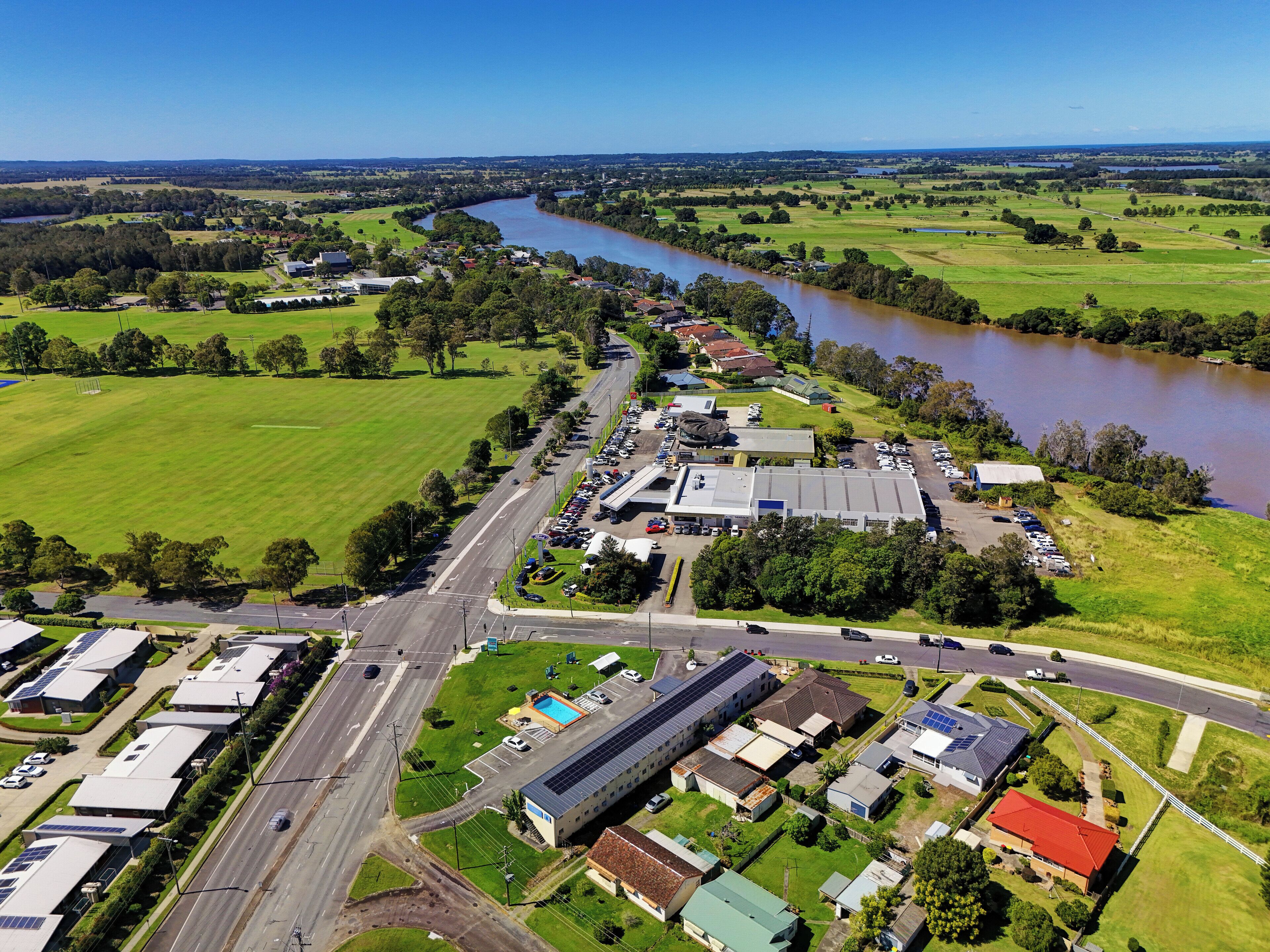 An industrial area with warehouses, a parking lot, and a river.